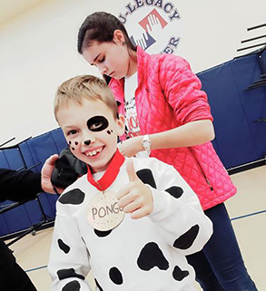 Smiling elementary school boy in a cow costume